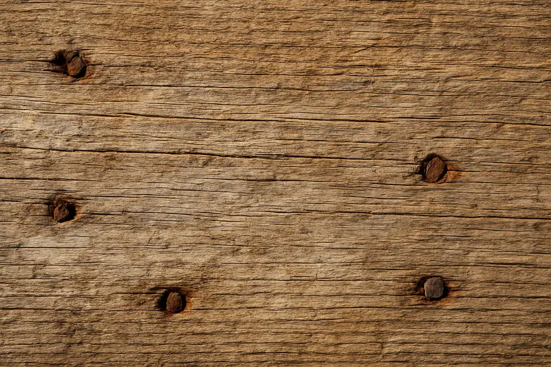 The grain of a weathered timber board with old nail holes — pole barn, Tyler. Illustrative example.