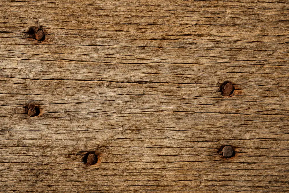 The grain of a weathered timber board with old nail holes — pole barn, Tyler. Illustrative example.